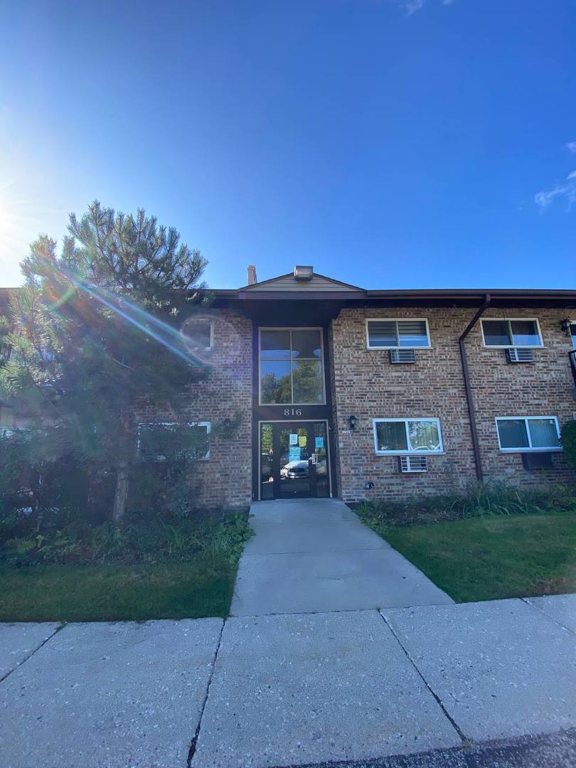 816 East Old Willow Road, Unit 112 Prospect Heights, IL 60070 - Photo 3 of 17 a front view of a house with a garden