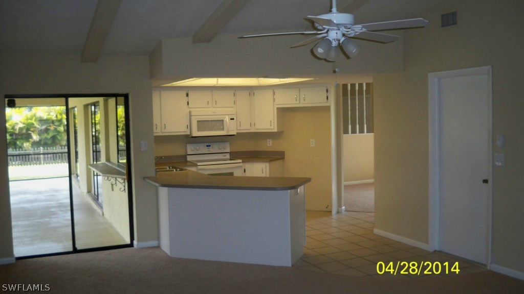 17513 Fuchsia Road Fort Myers, FL 33967 - Photo 4 of 12 a kitchen with kitchen island a counter top space and a ceiling fan