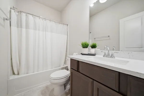 a bathroom with a sink a toilet and shower curtain