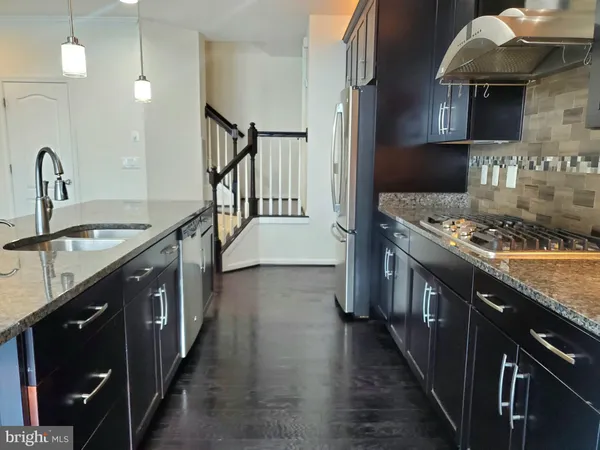 a kitchen with stainless steel appliances granite countertop a stove a sink dishwasher and cabinets with wooden floor