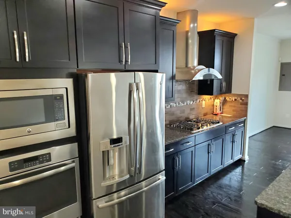 a kitchen with granite countertop a refrigerator and a stove