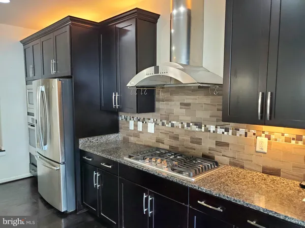 a kitchen with kitchen island granite countertop a sink stove and refrigerator