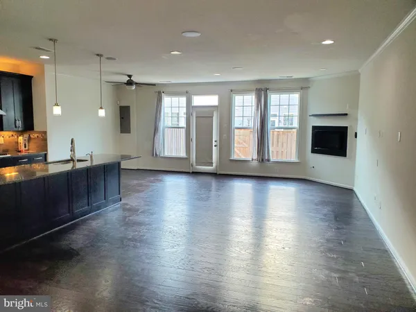 a view of a kitchen with wooden floor and a window