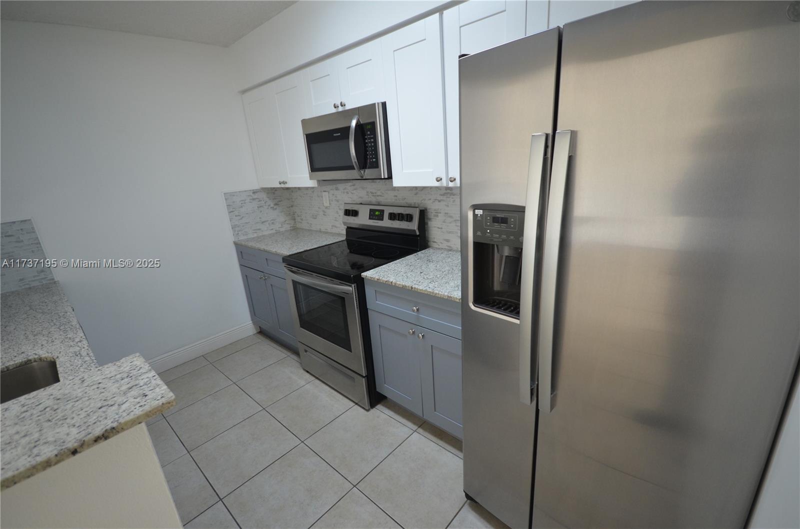 15201 Southwest 80th Street, Unit 207 Miami, FL 33193 - Photo 2 of 23 a kitchen with a sink appliances and cabinets