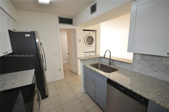 a kitchen with granite countertop a sink and a stove top oven