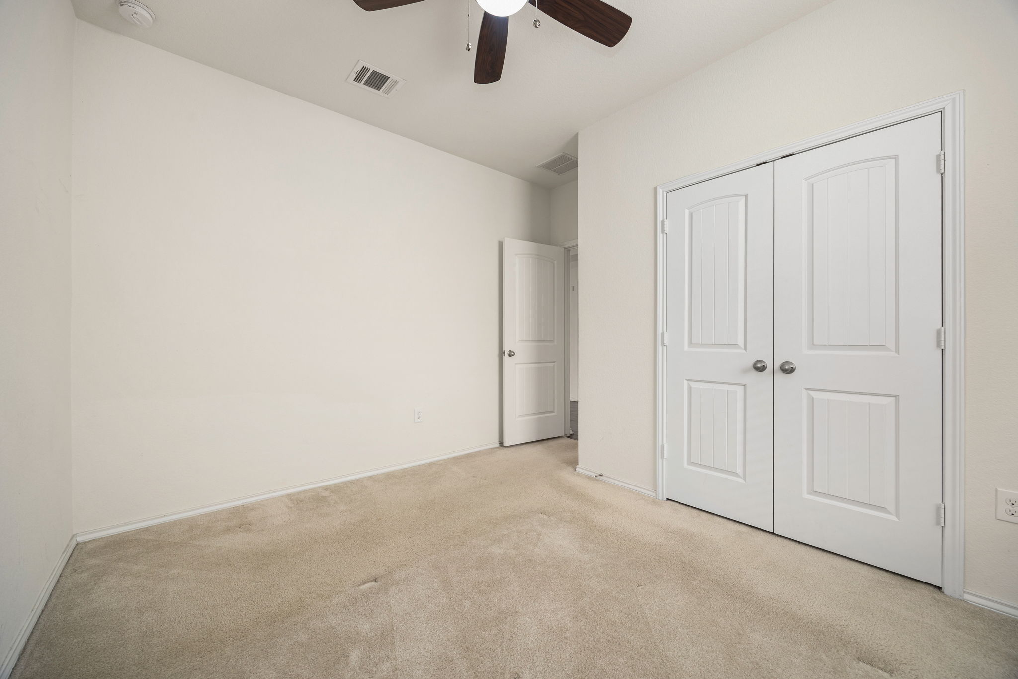 14615 Goshawk Drive Pflugerville, TX 78660 - Photo 11 of 29 an empty room with a ceiling fan and carpet