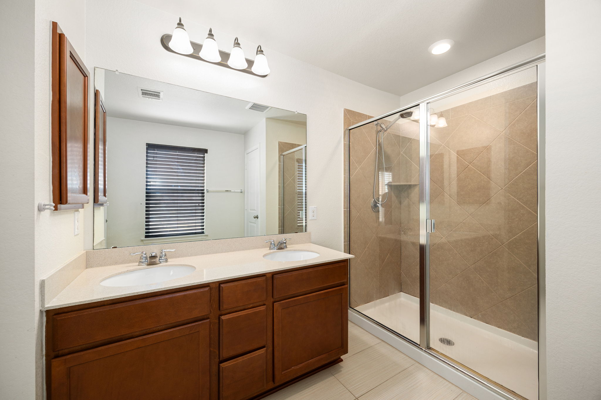 14615 Goshawk Drive Pflugerville, TX 78660 - Photo 18 of 29 a bathroom with a double vanity sink mirror and shower