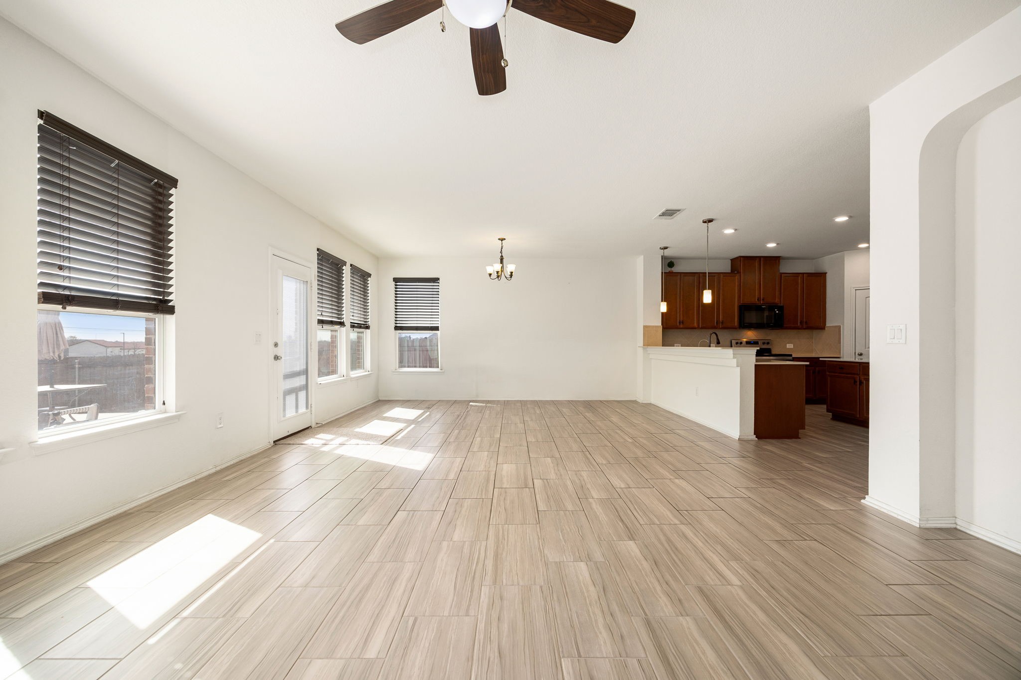 14615 Goshawk Drive Pflugerville, TX 78660 - Photo 6 of 29 a view of empty room with wooden floor and windows