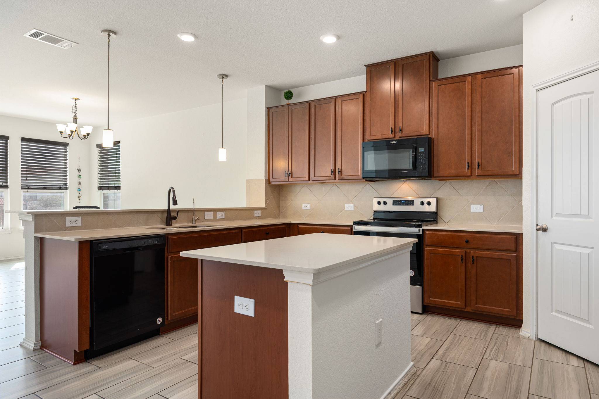 14615 Goshawk Drive Pflugerville, TX 78660 - Photo 8 of 29 a kitchen with stainless steel appliances granite countertop a sink a stove and a refrigerator