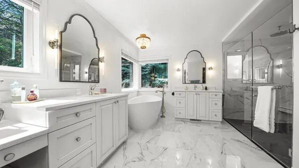 a spacious bathroom with a double vanity sink mirror and bathtub