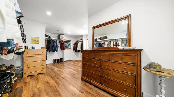a view of walk in closet with clothes and shoes