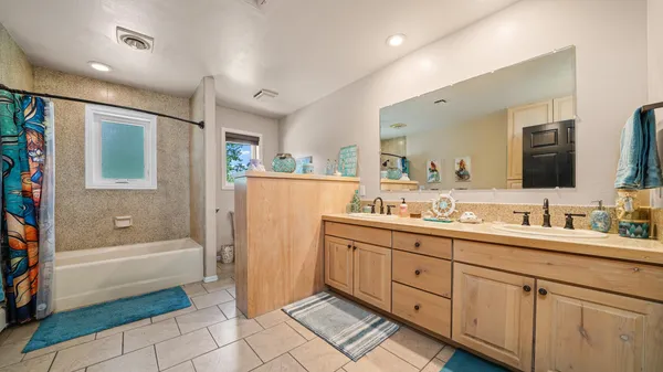 a bathroom with a tub sink and mirror