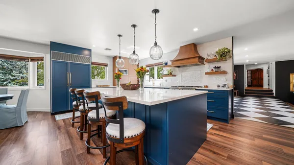 a kitchen with stainless steel appliances granite countertop a kitchen island a stove a table and chairs