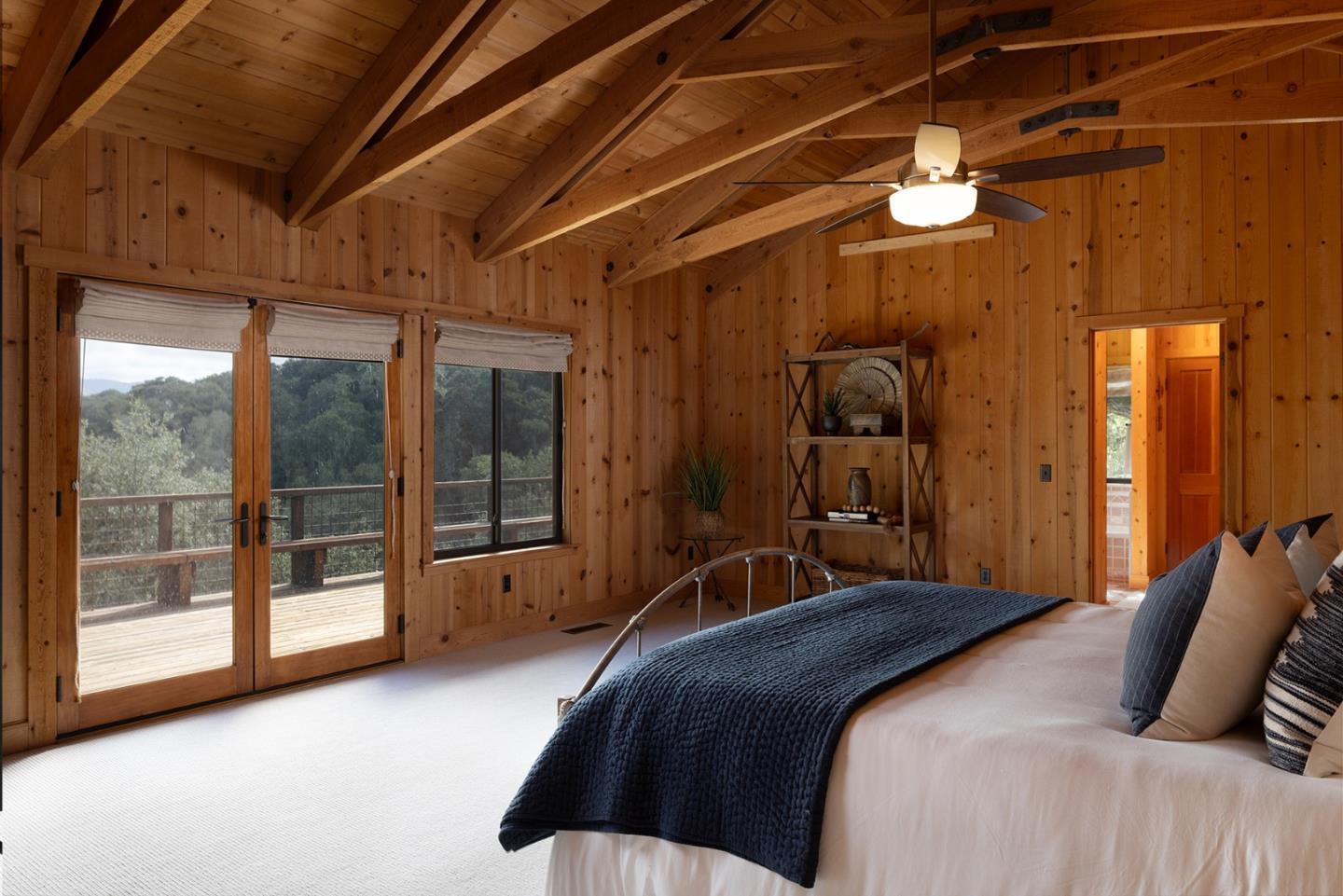 17094 Cachagua Road Carmel Valley, CA 93924 - Photo 25 of 42 a bedroom with a large bed and a chandelier