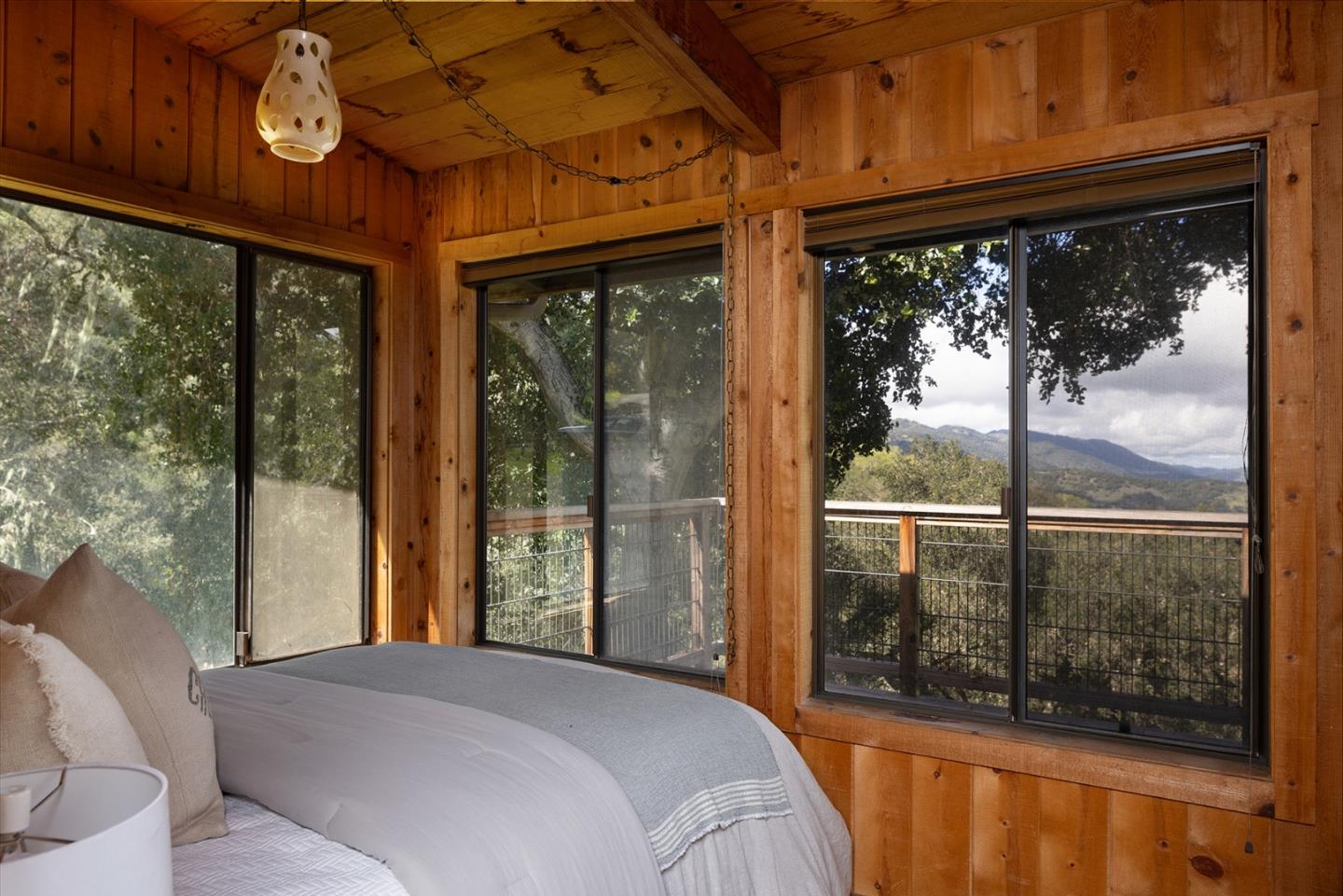 17094 Cachagua Road Carmel Valley, CA 93924 - Photo 40 of 42 a bedroom with a large window and a bed