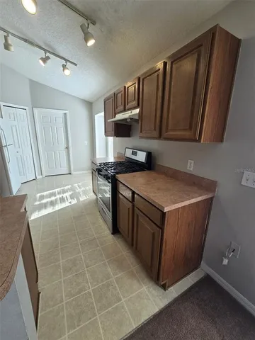 a kitchen with a sink a stove top oven and cabinets