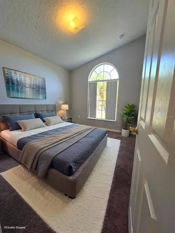 a bedroom with a bed and a large mirror on dresser