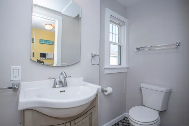 a bathroom with a sink toilet and mirror