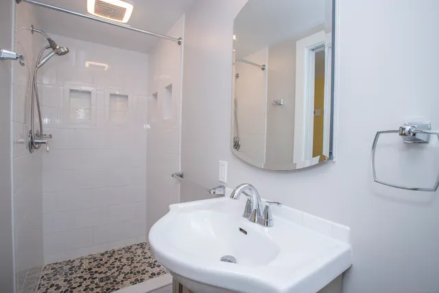 a bathroom with a sink a mirror and shower