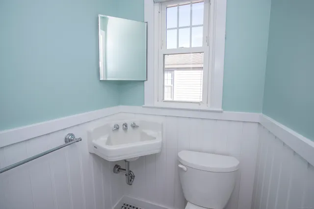 a bathroom with a sink a toilet and a window