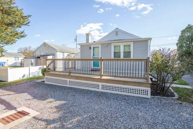 a view of a house with a deck and a yard