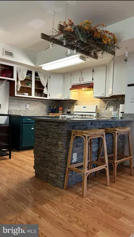 a kitchen with kitchen island a stove a table and chairs in it