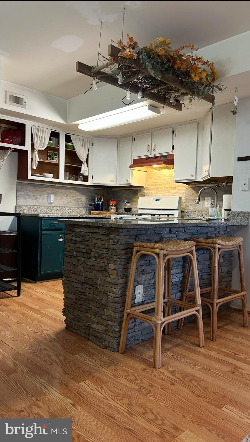 9200 Azure Court, Unit 201 Manassas, VA 20110 - Photo 5 of 20 a kitchen with kitchen island a stove a table and chairs in it