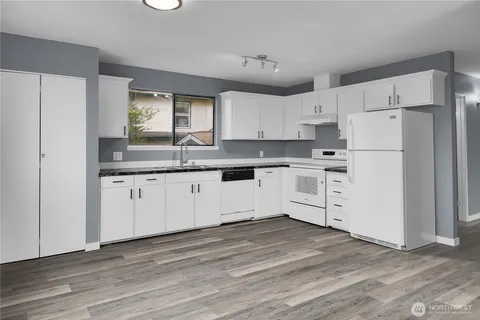 a kitchen with white cabinets and white appliances