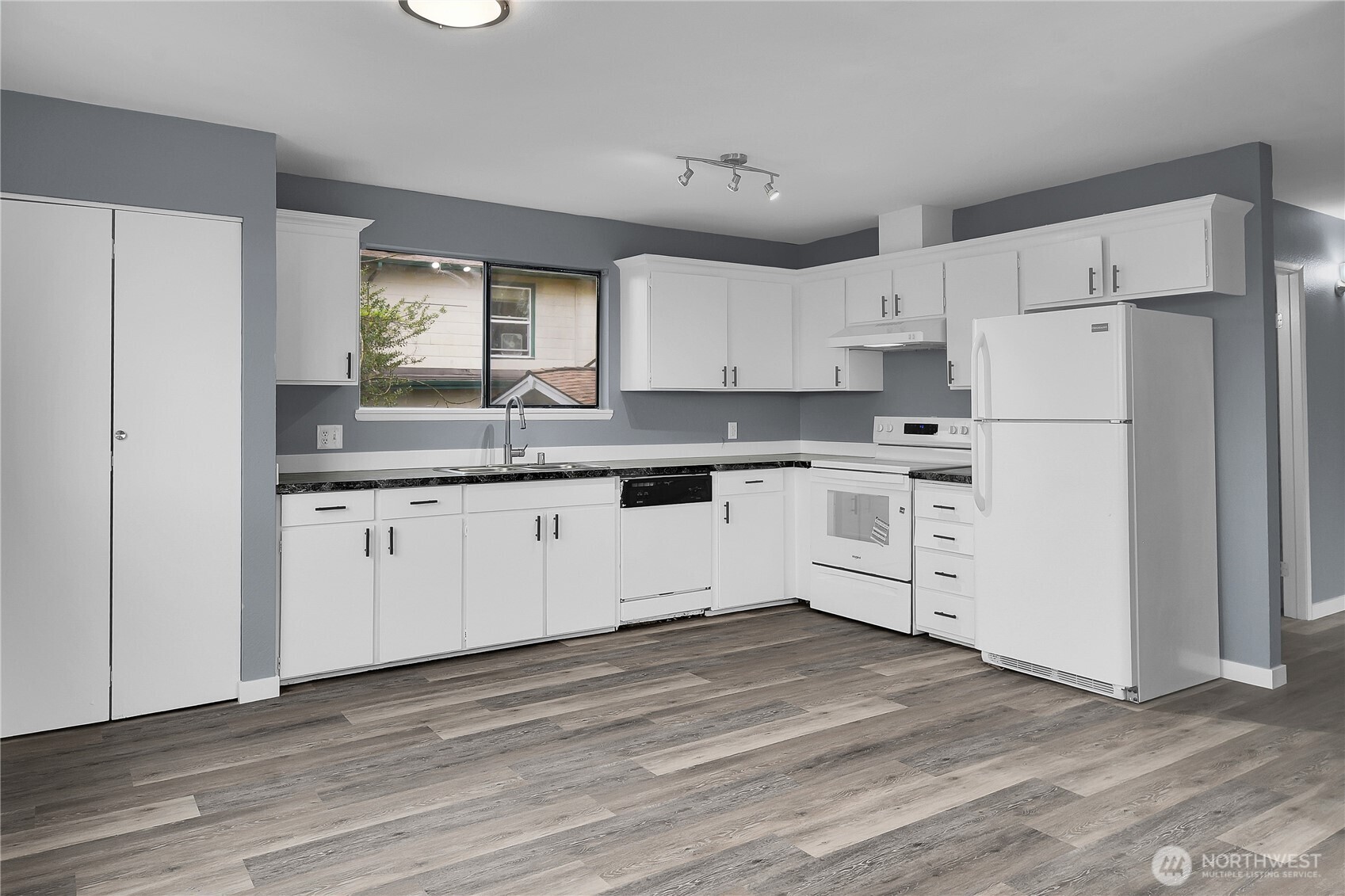 338 16th Avenue, Unit B Seattle, WA 98122 - Photo 1 of 7 a kitchen with white cabinets and white appliances