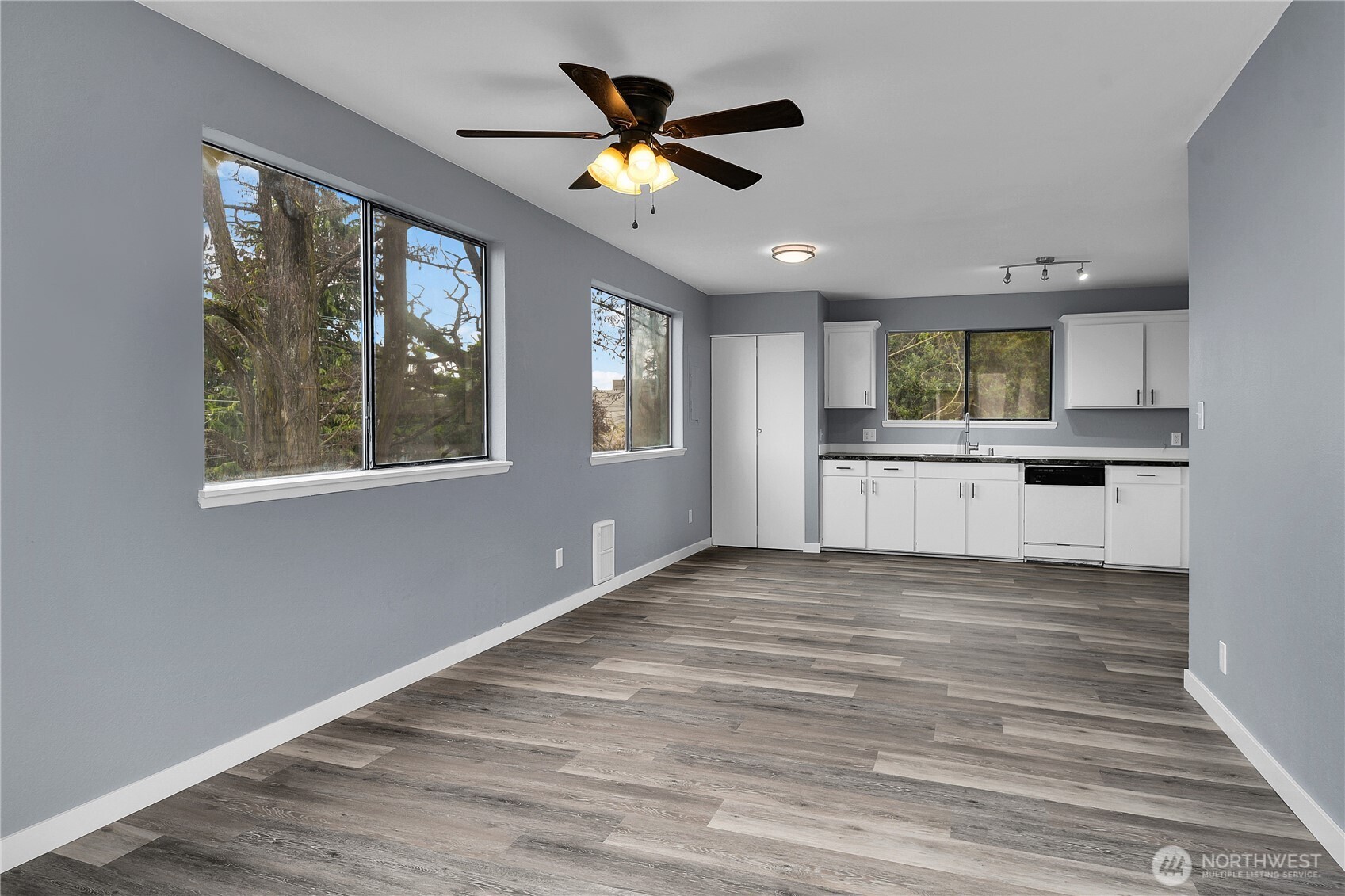 338 16th Avenue, Unit B Seattle, WA 98122 - Photo 3 of 7 a view of a kitchen with a stove cabinets a ceiling fan and wooden floor
