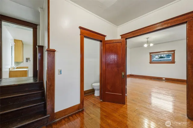 a view of a hallway with wooden floor and closet