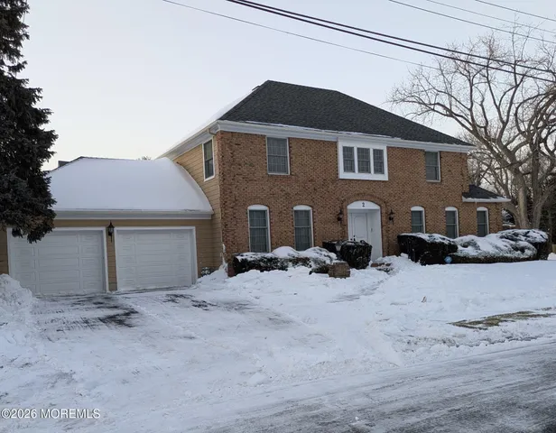 a front view of a house with a yard covered in snow