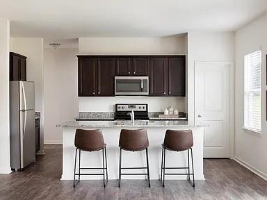 166 Verona Drive Northwest Cartersville, GA 30120 - Photo 4 of 13 a kitchen with stainless steel appliances granite countertop a stove a refrigerator a microwave a dining table and chairs