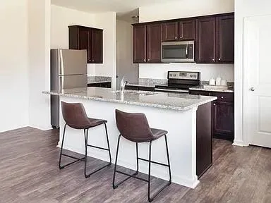 a kitchen with stainless steel appliances a stove refrigerator and microwave