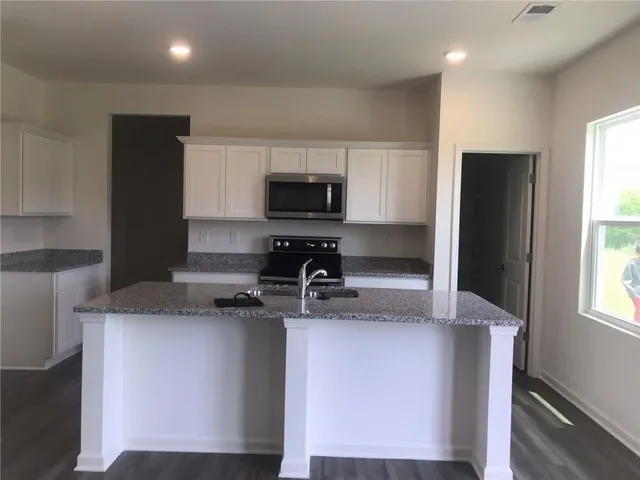 a kitchen with a refrigerator and a stove top oven