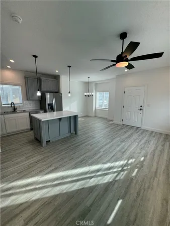 a living room with kitchen island furniture and a ceiling fan