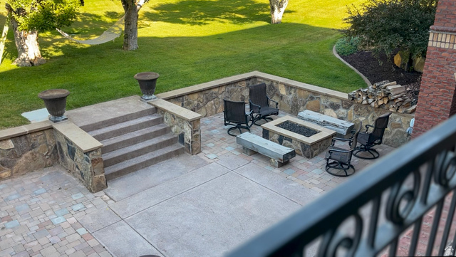 426 West Center Street Parowan, UT 84761 - Photo 79 of 107 Hardscaped patio area featuring a built-in fire pit, stone accent wall, and paver stone flooring