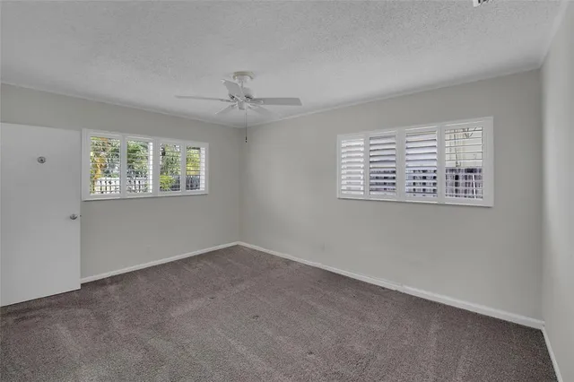 a view of a room with wooden floor and a ceiling fan