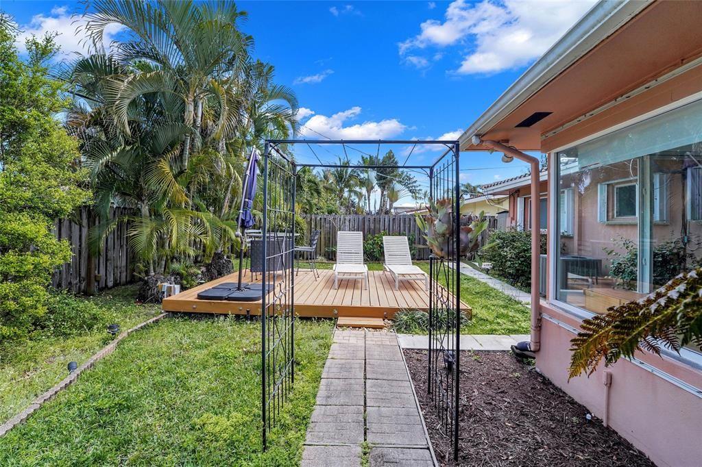 2725 Southeast 5th Court Pompano Beach, FL 33062 - Photo 34 of 37 a view of a patio with table and chairs potted plants and large tree