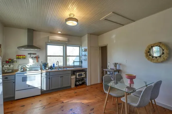 a kitchen with a dining table chairs and white cabinets