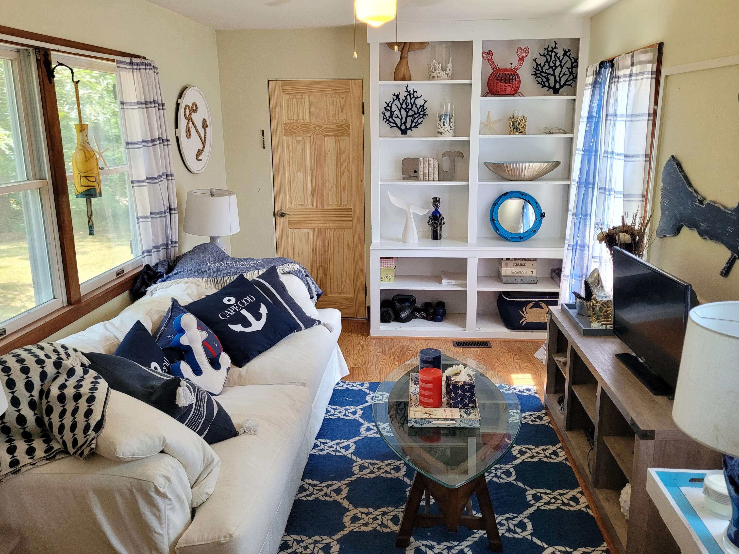 45 Designers Road Wellfleet, MA 02667 - Photo 16 of 84 a living room with furniture and a floor to ceiling window