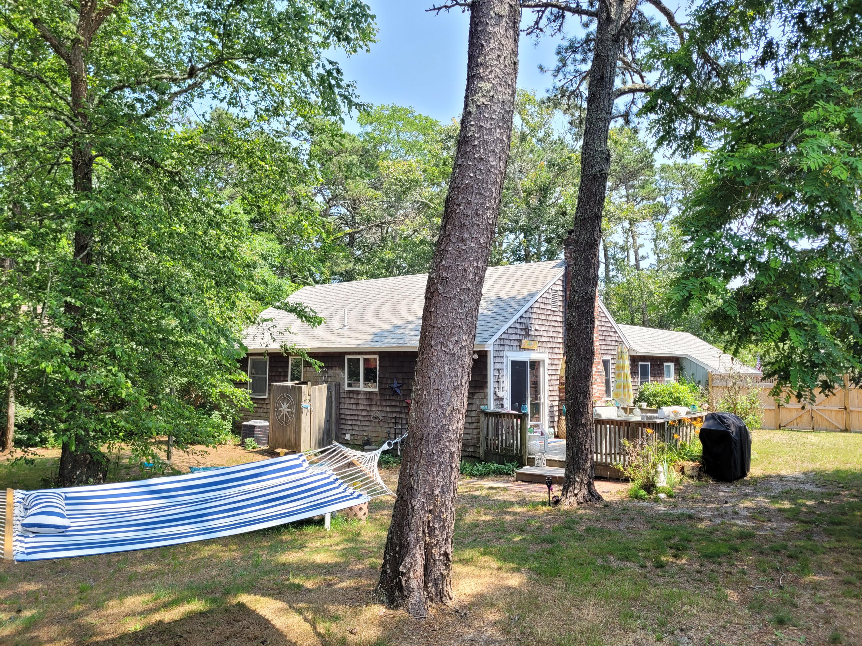 45 Designers Road Wellfleet, MA 02667 - Photo 2 of 84 a front view of a house with a yard table and chairs