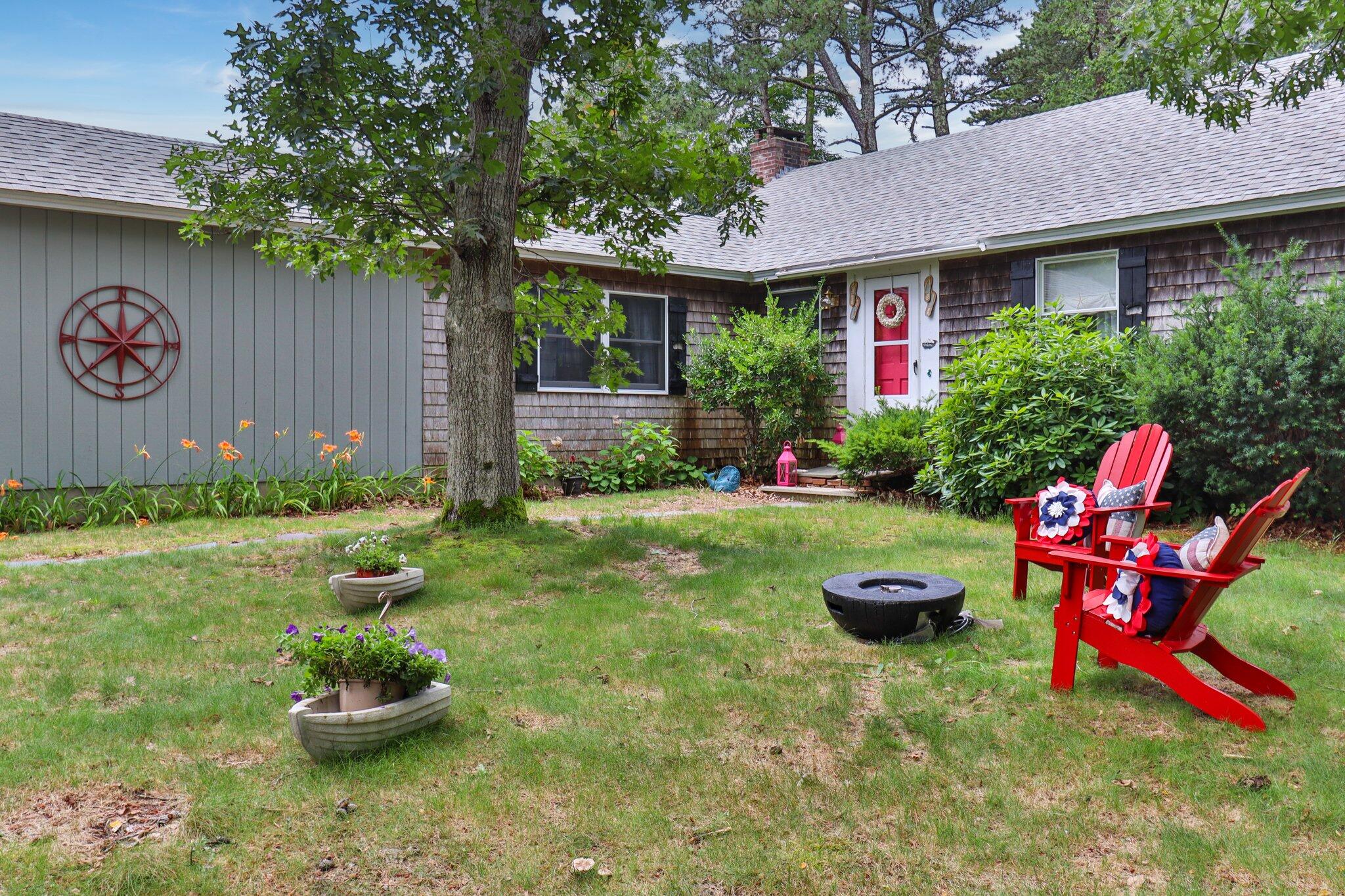 45 Designers Road Wellfleet, MA 02667 - Photo 62 of 84 a front view of a house with swing and plants