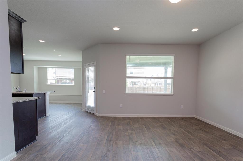 14614 Frankel Loop Pflugerville, TX 78660 - Photo 2 of 15 Recessed lighting illuminates this open-concept area featuring a breakfast bar and durable wood-look flooring.