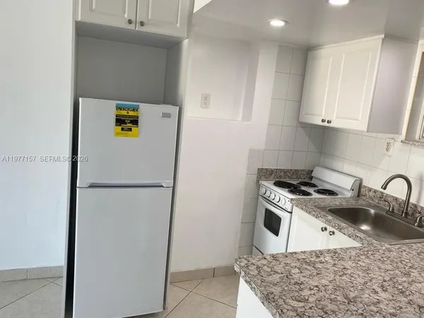 a white refrigerator freezer sitting inside of a kitchen