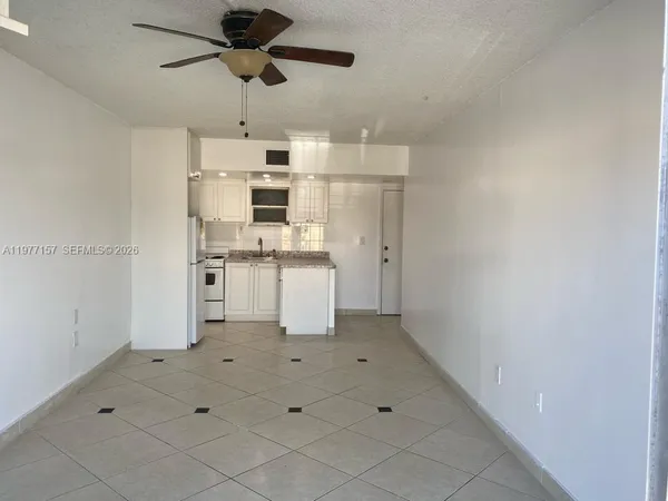 a kitchen with stainless steel appliances a stove refrigerator and white cabinets