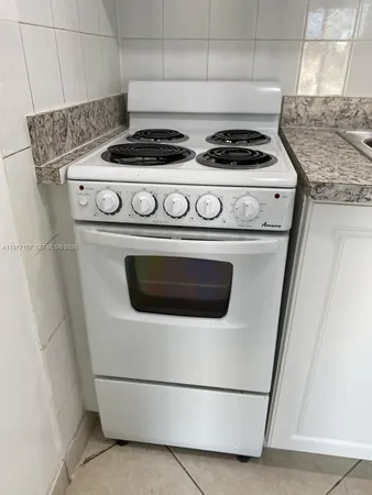 a stove top oven sitting inside of a kitchen