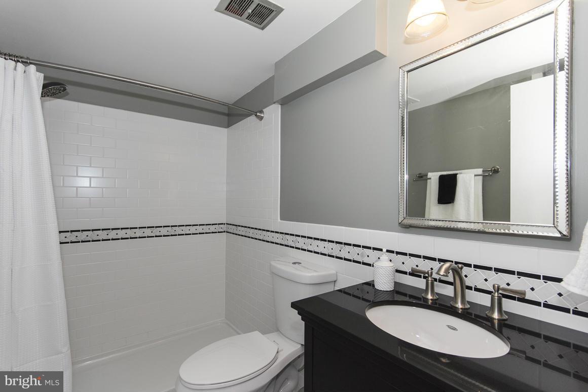 121 Cross Keys Road, Unit A Baltimore, MD 21210 - Photo 12 of 24 a bathroom with a sink vanity mirror and toilet