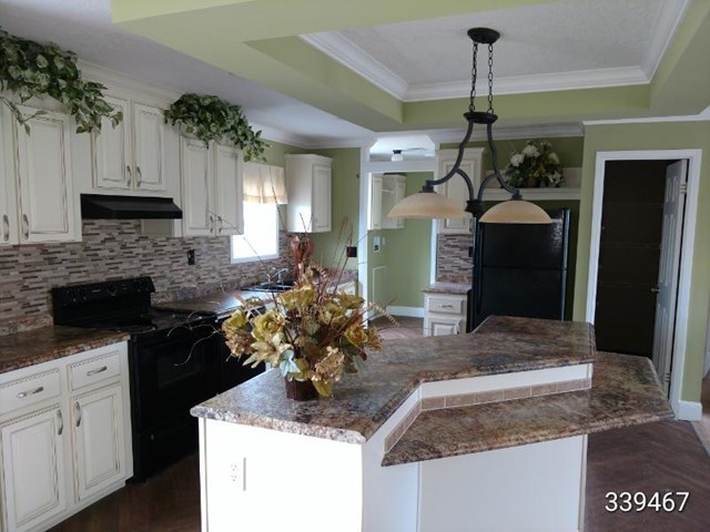 139 Roy Bryant Road Cochran, GA 31014 - Photo 12 of 14 a kitchen with kitchen island granite countertop a sink a counter and cabinets