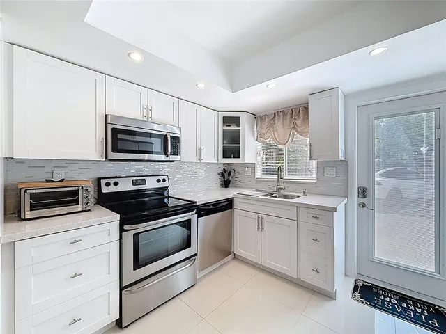 a kitchen with sink a microwave and cabinets
